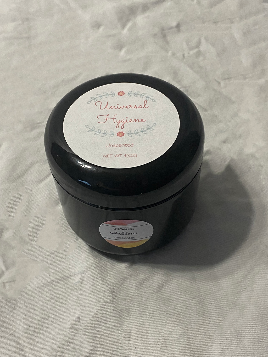 Black container with a label on a textured gray background