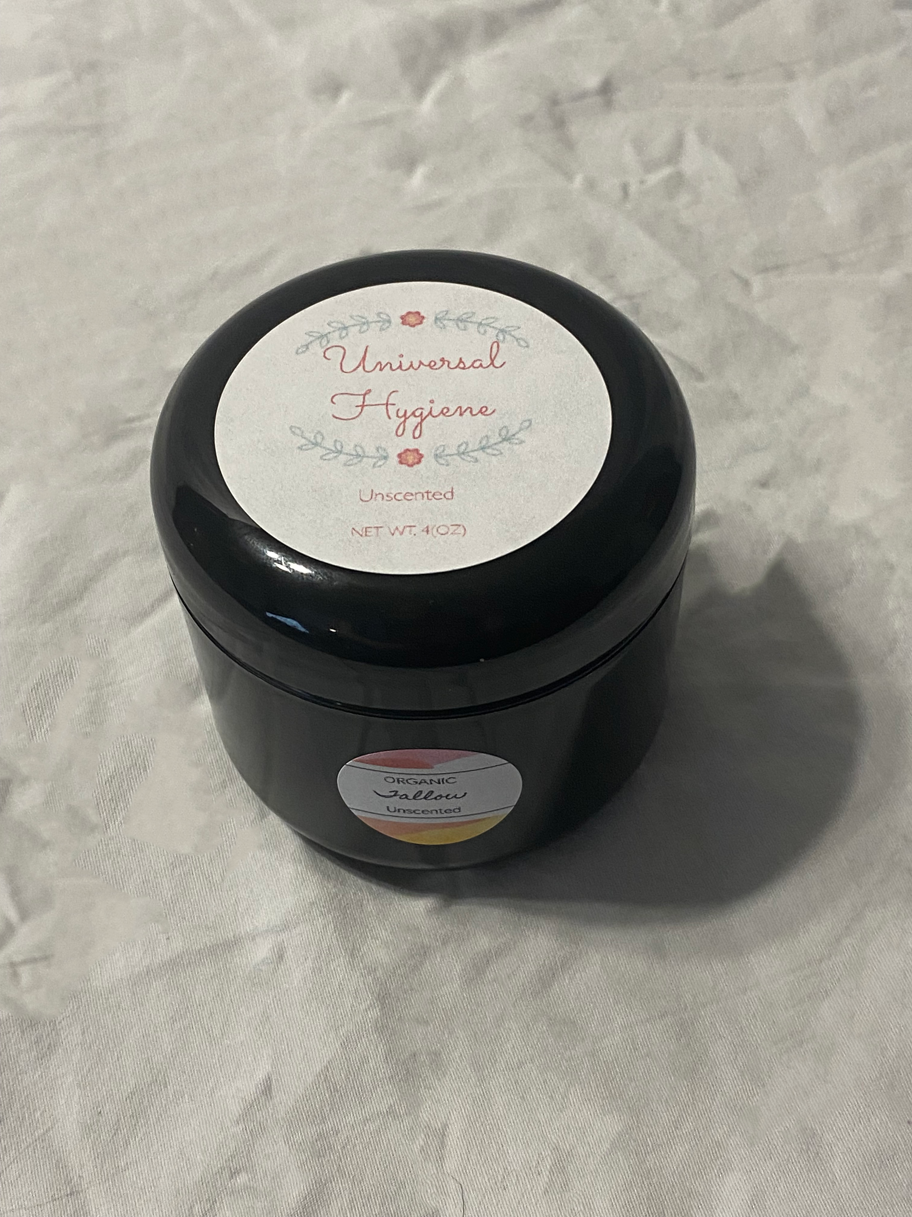 Black container with a label on a textured gray background